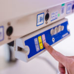 A formative usability participant is pressing a medical device button.