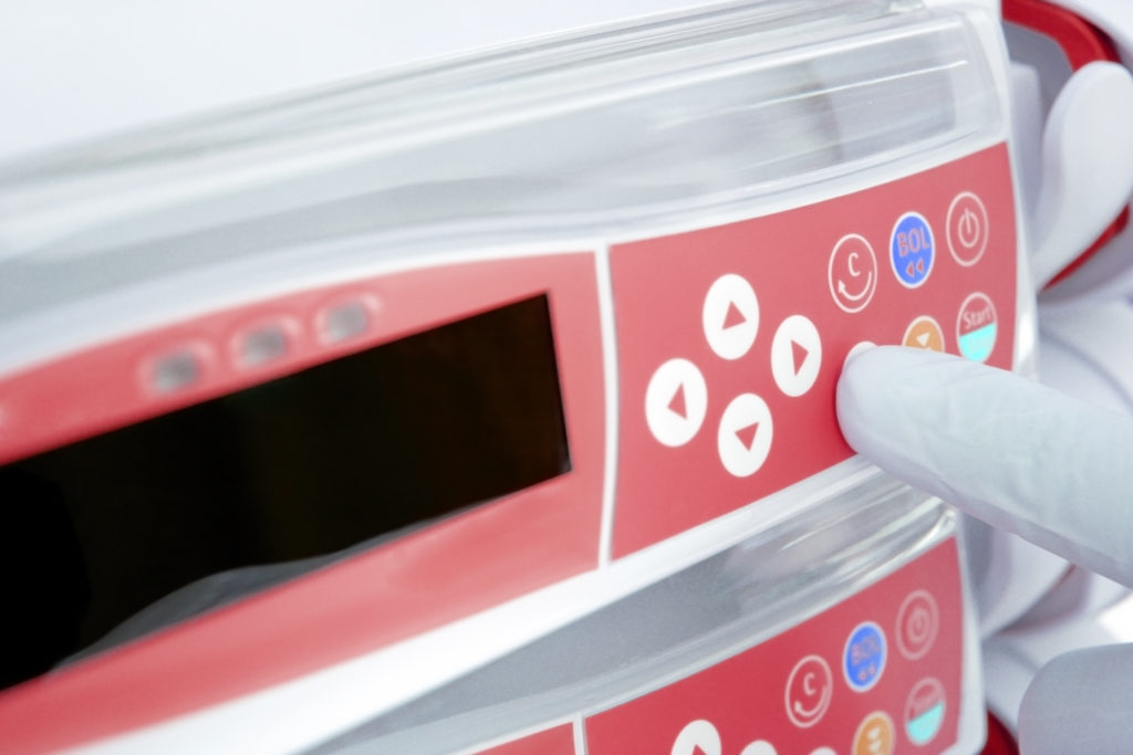 A medical device user presses a button